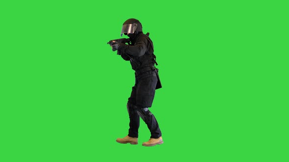 Masked Armed SWAT Police Officer Walking and Aiming with Rifle on a Green Screen Chroma Key alt