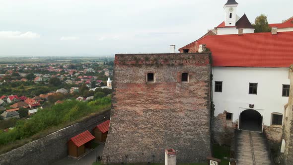 Drone Flies Over Medieval Castle on Mountain in Small European City at Cloudy Autumn Day alt