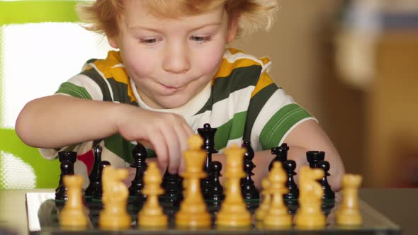 Pre-school Boy Fascinated by the Game of Chess.
