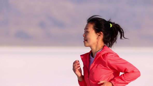 Asian woman jogging across the Bonneville Salt Flats flats alt