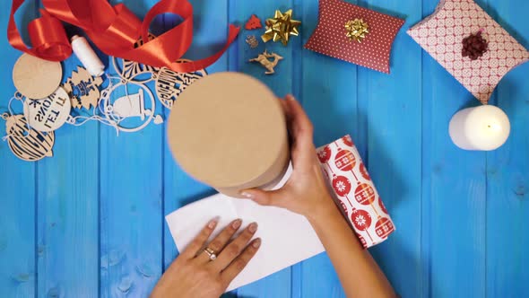 Hands wrapping a gift box alt