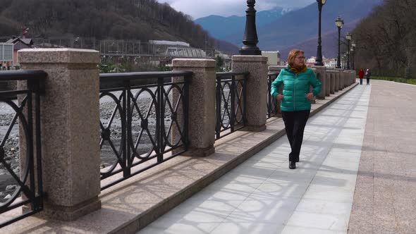 Senior Woman Having a Lonely Walk in Highland Town alt