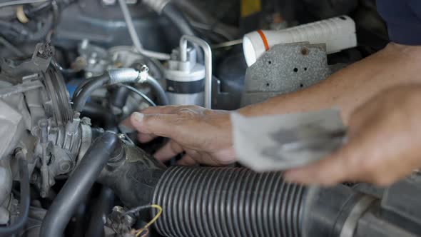 Hands Of An Auto Mechanic Using Epoxy Resin To Fix The Leak On Radiator Hose Of A Car alt