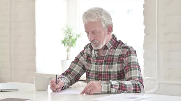 Serious Casual Old Man Doing Paperwork in Office alt