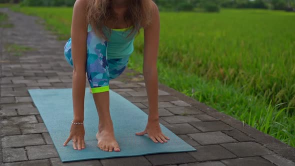 Slowmotion Shot of a Young Woman Practicing Yoga on a Beautiful Rice Field alt