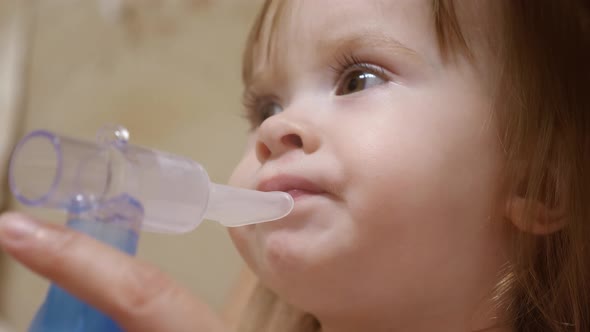 Child Is Sick and Breathes Through an Inhaler. Toddler Treats Flu By Inhaling Inhalation Vapor alt