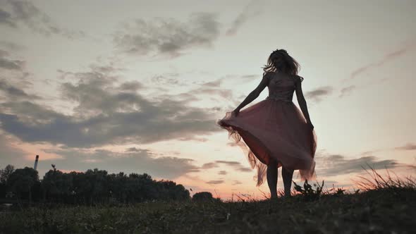 The Girl in the Dress Swirls Magically at Sunset alt