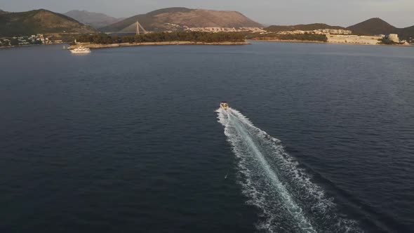 A speedboat speeds across the Adriatic sea near Dubrovnik, Croatia - Aerial alt