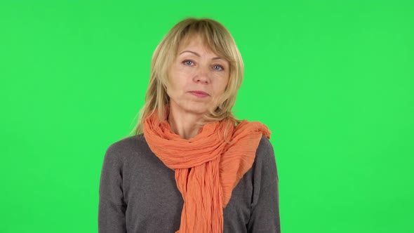 Portrait of Middle Aged Blonde Woman Is Shrugging and Sighing. Green Screen alt