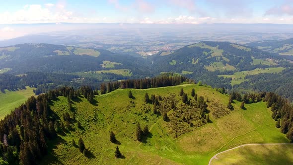 Aerial shot over Alpine landscape, Switzerland in springForest and Alpages alt