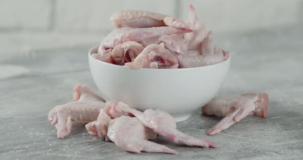 Fresh Raw Chicken Pieces of Wings in the Bowl Rotate.  alt