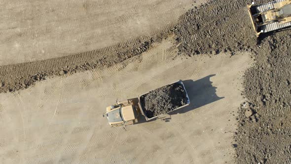 A Lorry Moving Substrate for a Bulldozer to Flatten in Construction alt