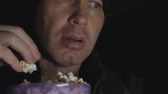 Emotional Man Watches a Scary and Interesting Movie on TV in the Dark and Eats Popcorn From a alt