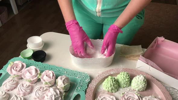 The Woman Sprinkles The Marshmallow With Powdered Sugar. alt