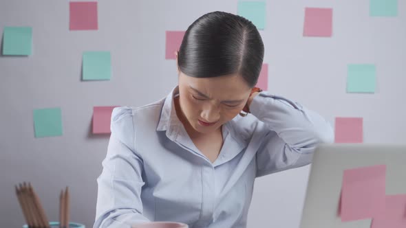 Asian woman working on a laptop was sick with body pain sitting