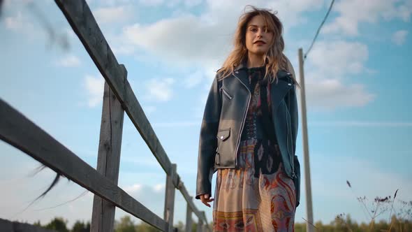 Stylish Lady Walking Near Fence in Countryside alt