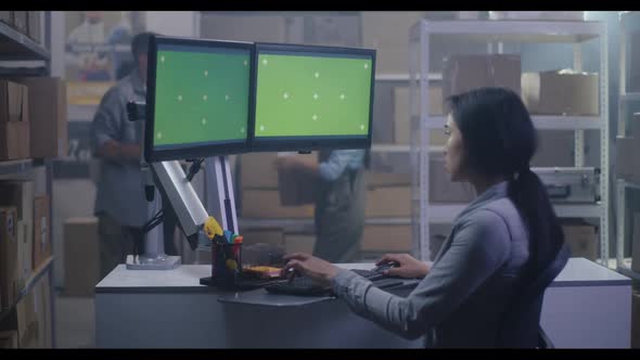 Young Woman Working at a Computer in a Distribution Center alt