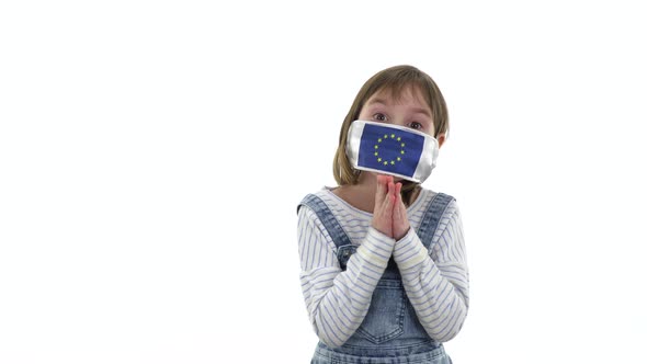 On the child a protective medical mask with the flag of the European Union.