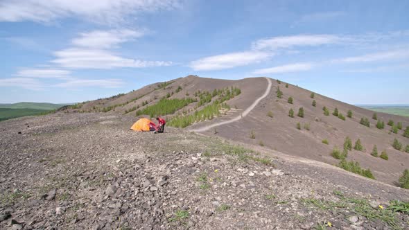 Female Hiker Preparing Campsite in Mountains alt