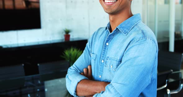 Male executive standing with arms crossed in office 4k alt