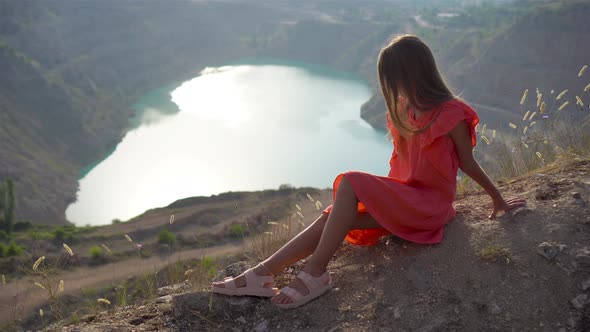 Little Girl Near the Lake at the Day Time with Amazing Nature on Background