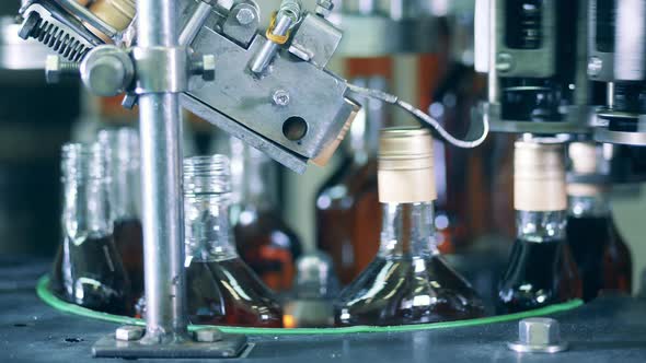 Spinning Conveyor Is Closing Bottles Cognac alt
