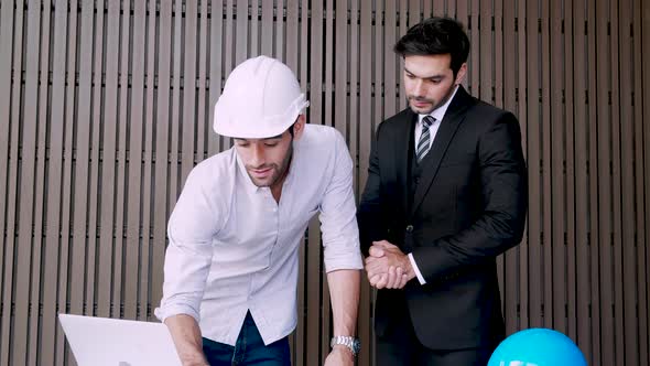 Two architects working together with laptop in concept of discussing project plan solar panels power alt