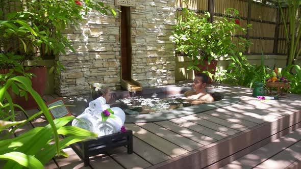 A couple bathing in a spa jacuzzi whirlpool bathtub hot tub. alt
