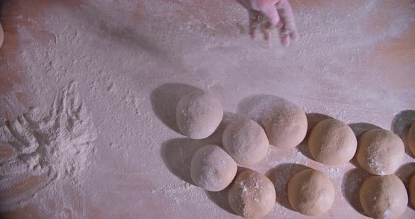 Slow Motion Shot of Bakery Chef Applying and Sprinkles Flour Over Bread Dough