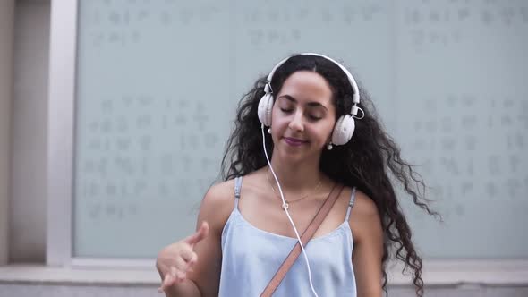 Teenage Girl with Headphones Listening to Music Singing and Dancing alt