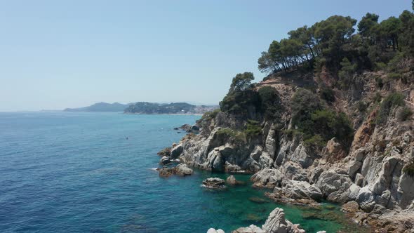 Aerial View of Rocky Coast and Blue Sea Water alt
