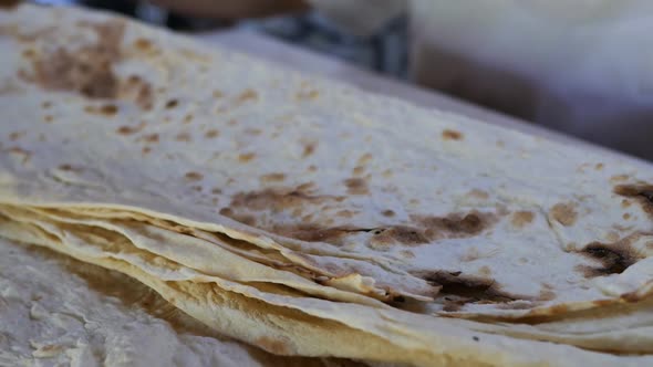 Female Hands Take Many Layers of Fresh Traditional Pita and Cut with a Knife