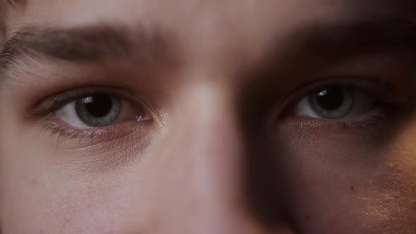 Closeup of Blueeyed Young Man Opening and Closing Eyes Blinking Looking in Camera alt