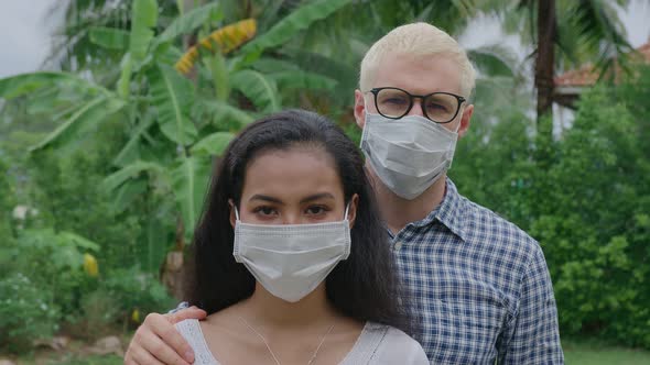 Portrait of an International Couple in Love a European Man and an Asian Woman Wearing a Face Mask alt