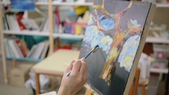 Master of Painting Is Making Strokes on Picture in Studio Closeup alt