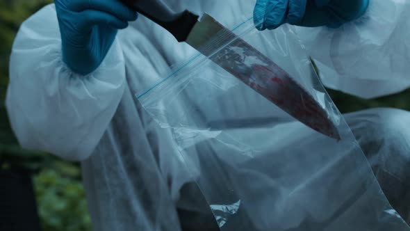 Criminalists Discovering Knife at Crime Scene Closeup Taking Evidence From Accident Murder alt