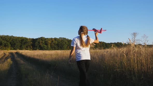 Small Female Child Running with Plane in Hand Through Country Road alt