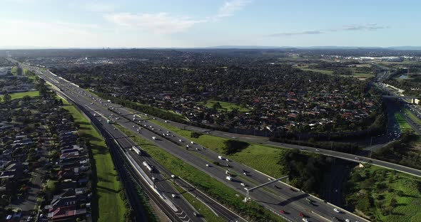 Slow tracking ad revealing major highway intersection below as many vehicles enter main carriage way alt