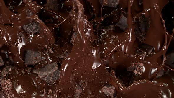 Super Slow Motion Shot of Raw Chocolate Chunks Falling Into Melted Chocolate at 1000 Fps alt