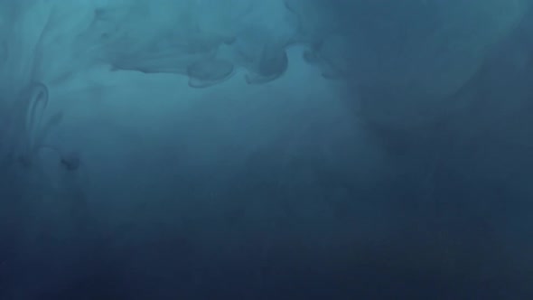 Dark blue ink falling into dark blue water and dissolving. Macro shot, sideview. alt