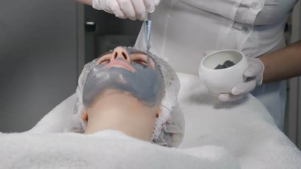 Young Pretty Woman Getting Procedures in Beauty Salon. Young Beautiful Woman Lying on Couch alt