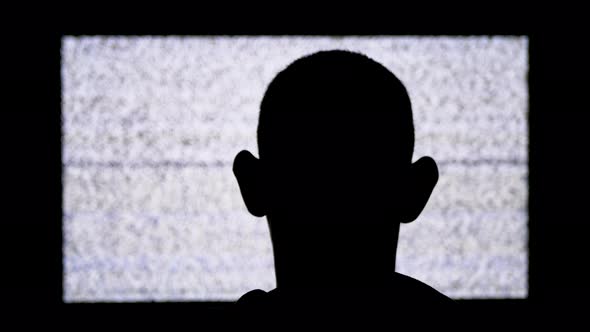 Silhouette of an Anonymous Man's Head Is Watching White Static Noise and TV Interference alt