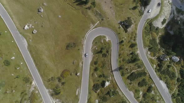 Aerial Birdview of Mountain Road in the Italian Dolomites with a Few Cars Driving alt