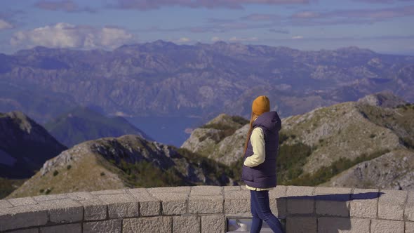 A Young Woman Traveler Visits the View Point on the Top of the Lovcen Mountain alt