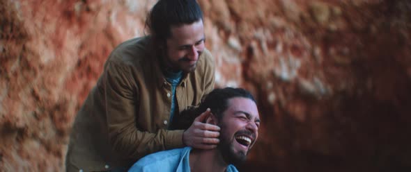 Two friends relaxing on the beach after the sunset with the dog alt