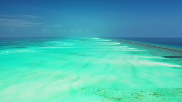 Wide above copy space shot of a white paradise beach and blue water background in colourful 4K alt