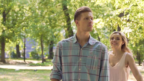 Anxious Man Waiting for Date in Park, Beautiful Girl Hugging Him by Surprise alt