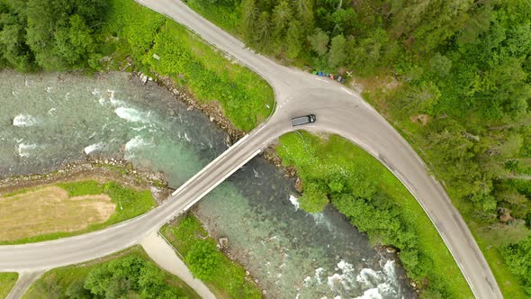 Vehicle Passes On Small Bridge Over Watercourse In Geiranger, Norway. aerial top-down alt