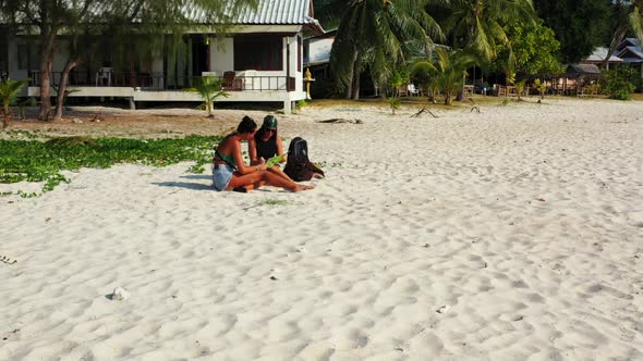 Beautiful ladies enjoying life on paradise island beach break by shallow water with white sand backg alt