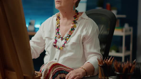 Retired Female Artist Drawing Artwork on Canvas with Pencils alt